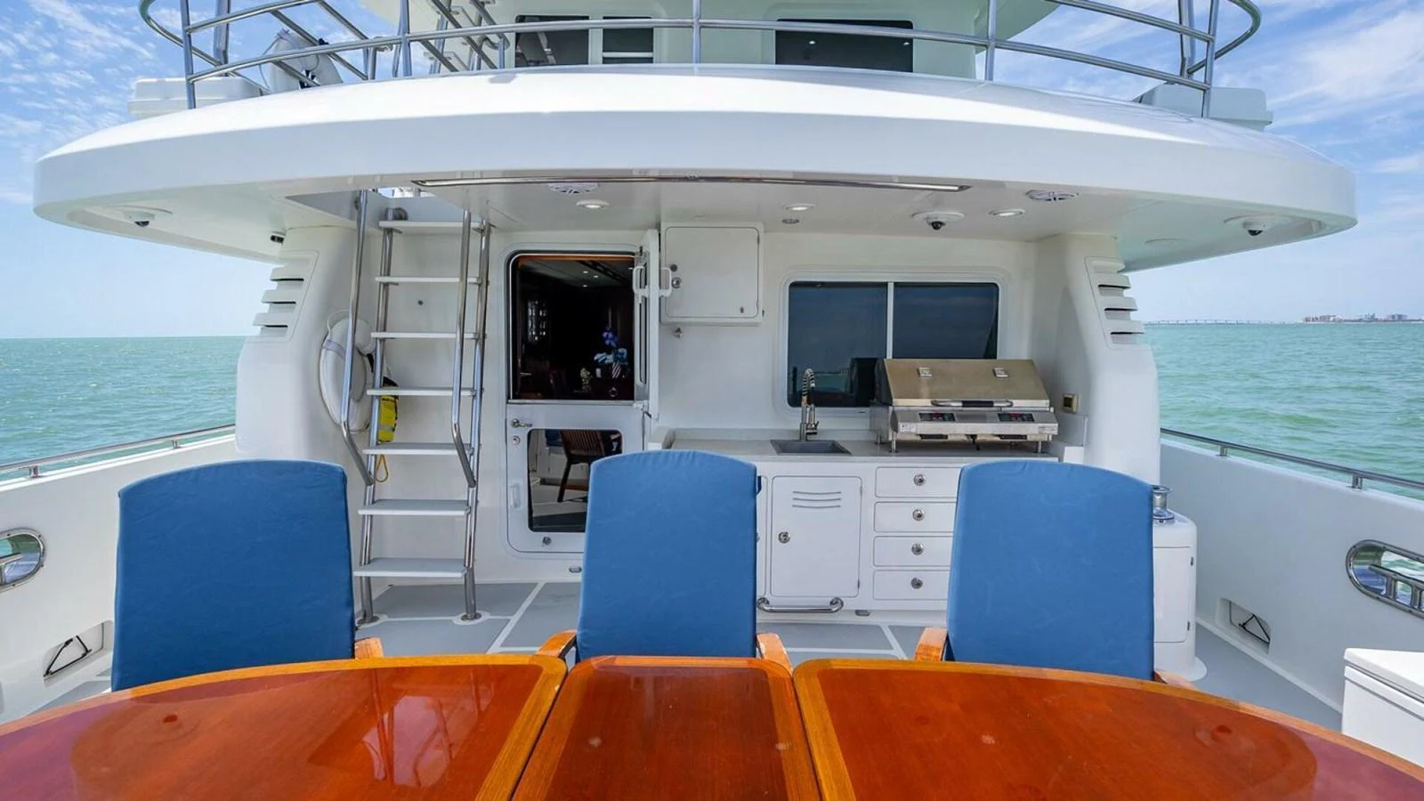 The aft deck features a spacious dining area with a view of the sea. aboard TAKE 5 Yacht for Sale