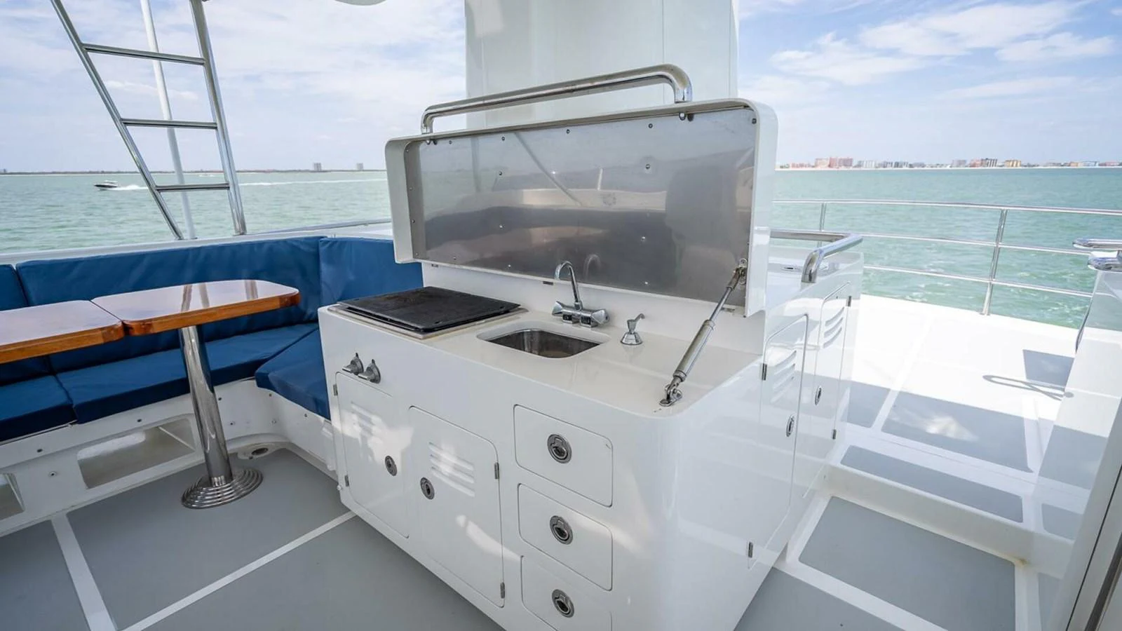 The yacht features a well-equipped outdoor galley with a sink, grill, and ample storage, perfect for alfresco dining. aboard TAKE 5 Yacht for Sale