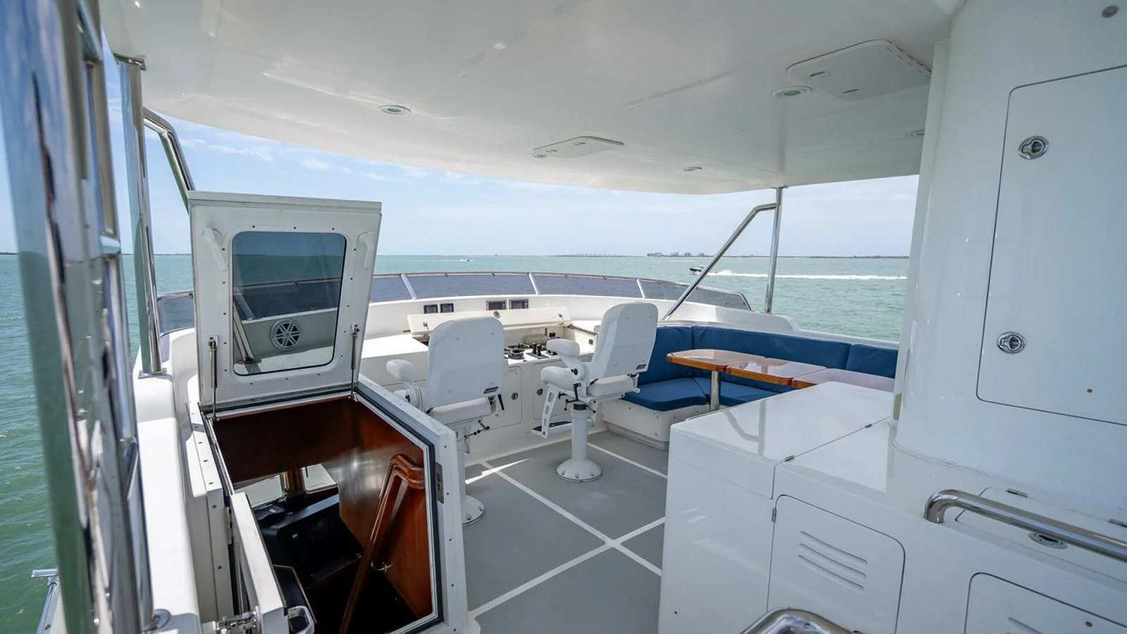 The flybridge offers a spacious and comfortable area with seating and a helm station, perfect for enjoying the open sea views. aboard TAKE 5 Yacht for Sale