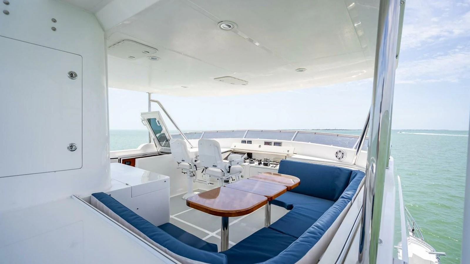 The yacht's helm area features a comfortable seating arrangement with a central table and a well-equipped control station. aboard TAKE 5 Yacht for Sale