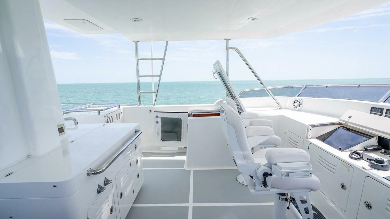 The helm station offers a pristine view of the open sea with modern navigation equipment and comfortable seating. aboard TAKE 5 Yacht for Sale