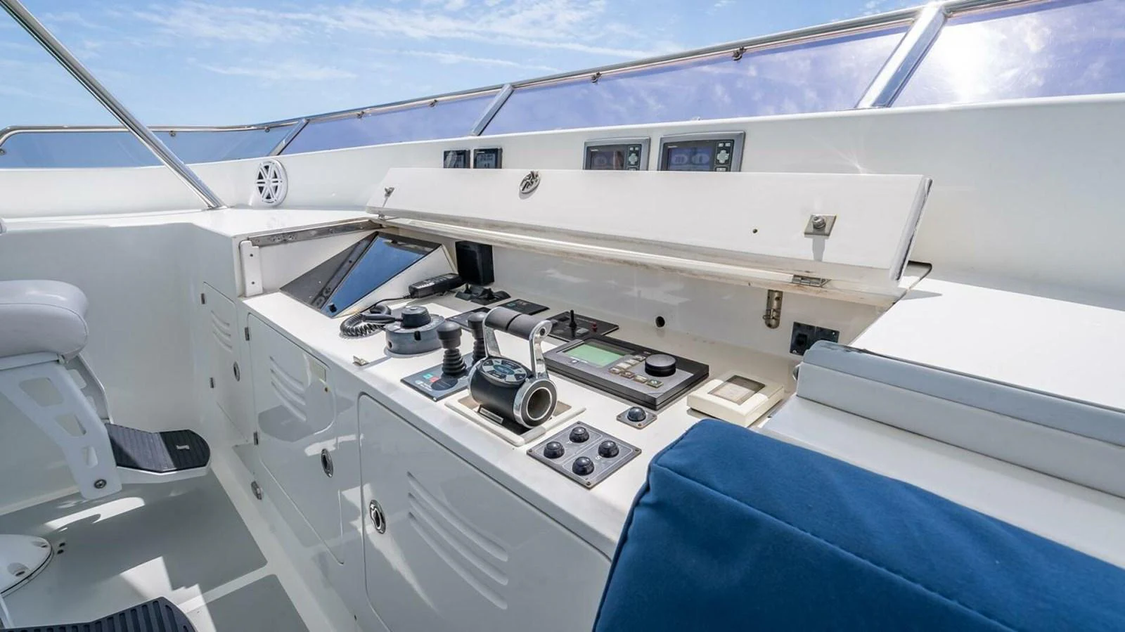 The helm station features modern navigation equipment and a comfortable seating area, all bathed in natural light. aboard TAKE 5 Yacht for Sale