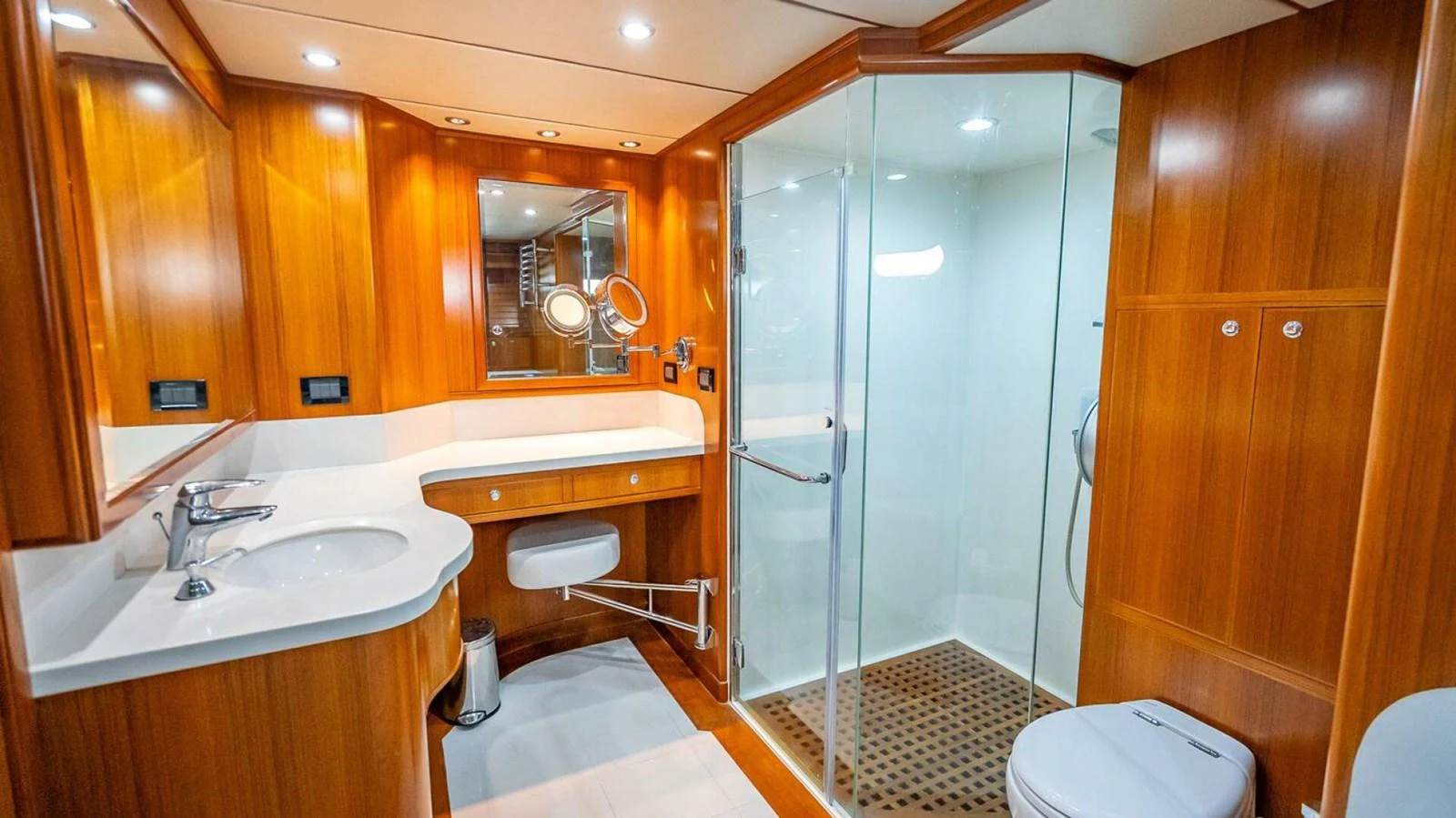 The yacht's bathroom features elegant wood paneling, a spacious shower, and modern fixtures. aboard TAKE 5 Yacht for Sale