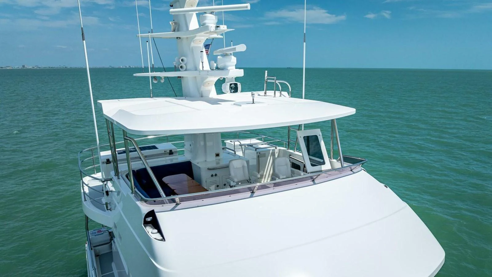 A sleek yacht cruising on calm waters under a clear blue sky. aboard TAKE 5 Yacht for Sale