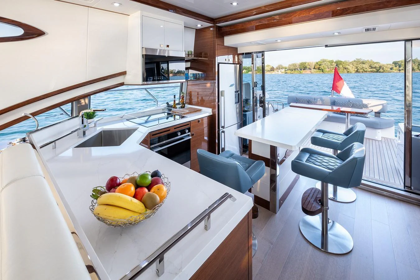 The yacht's galley features modern appliances, a sleek countertop, and a comfortable dining area with a view of the water. aboard NEPTUNUS 650E Yacht for Sale