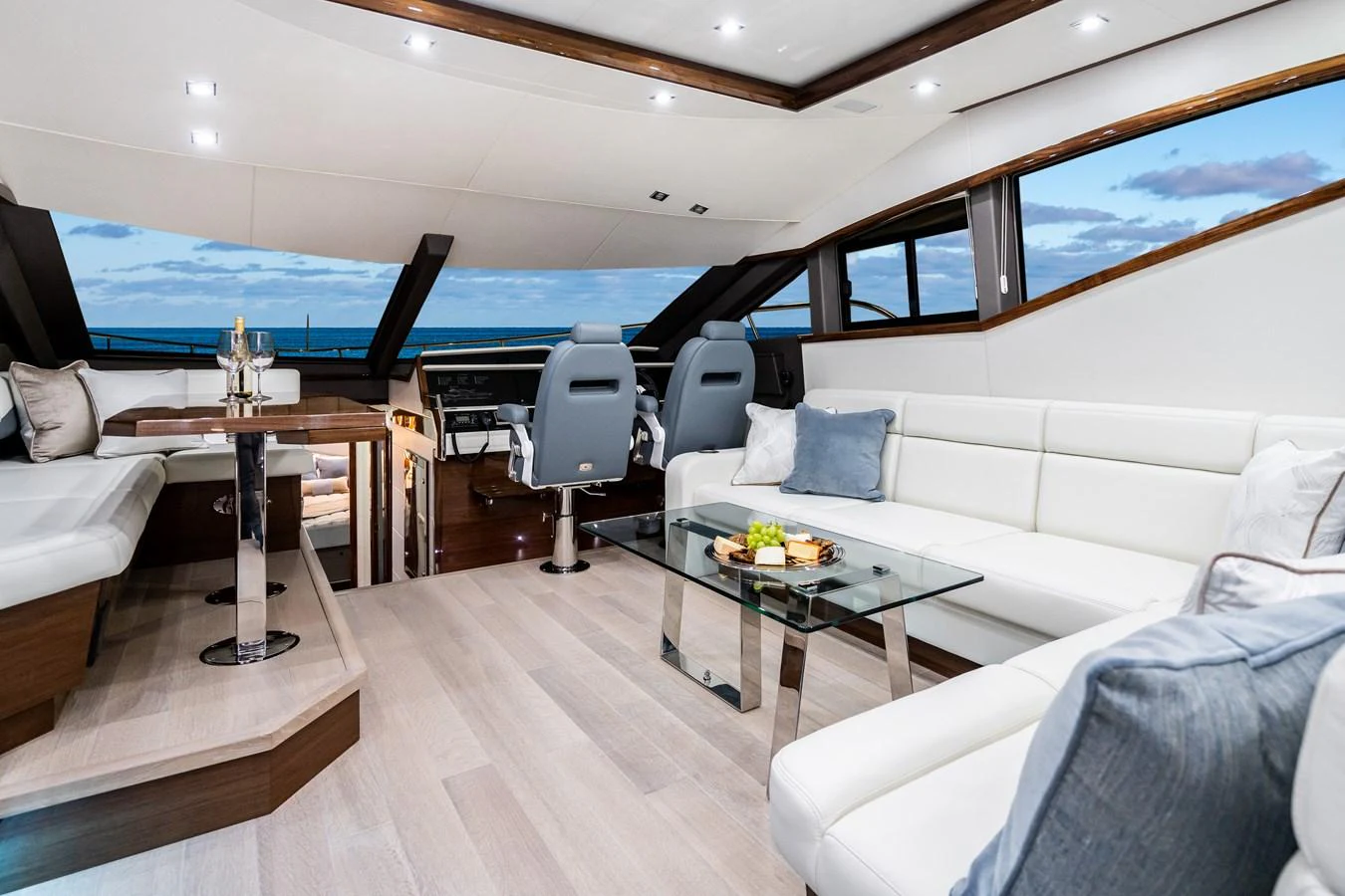 The salon features a spacious seating area with modern furnishings and panoramic windows offering stunning ocean views. aboard NEPTUNUS 650E Yacht for Sale