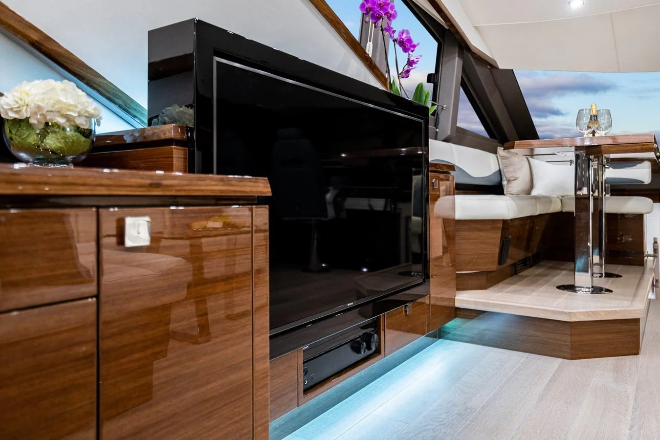 The yacht's salon features a sleek entertainment area with a large TV and elegant wood finishes. aboard NEPTUNUS 650E Yacht for Sale