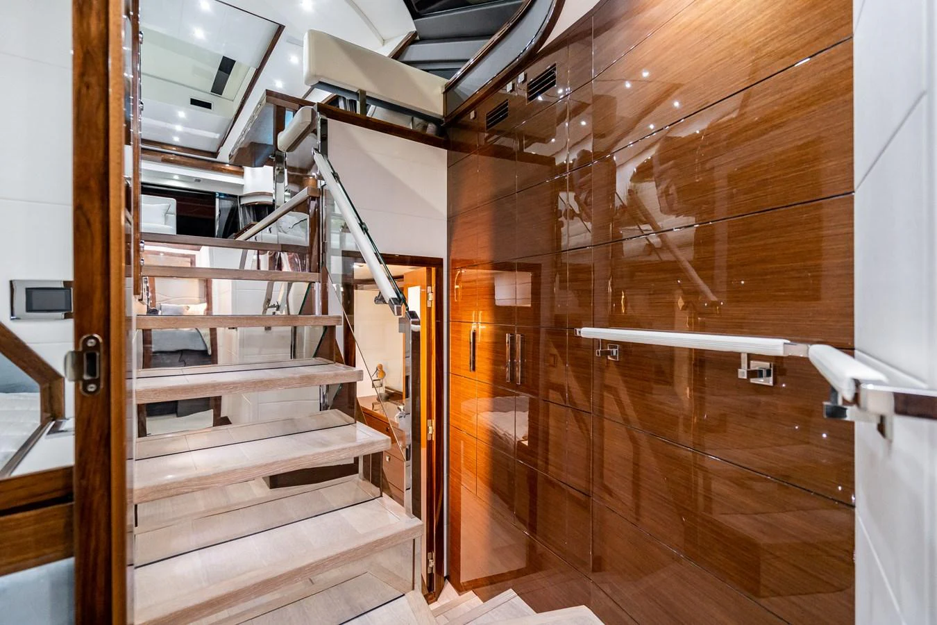 The yacht's interior features a sleek, modern staircase with polished wood and stainless steel accents. aboard NEPTUNUS 650E Yacht for Sale