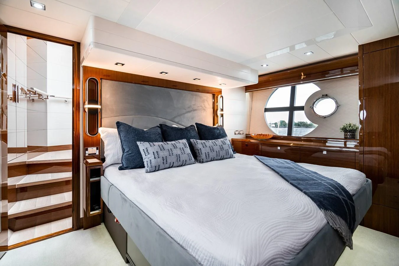 The stateroom features a luxurious bed with elegant wood paneling and ample natural light. aboard NEPTUNUS 650E Yacht for Sale