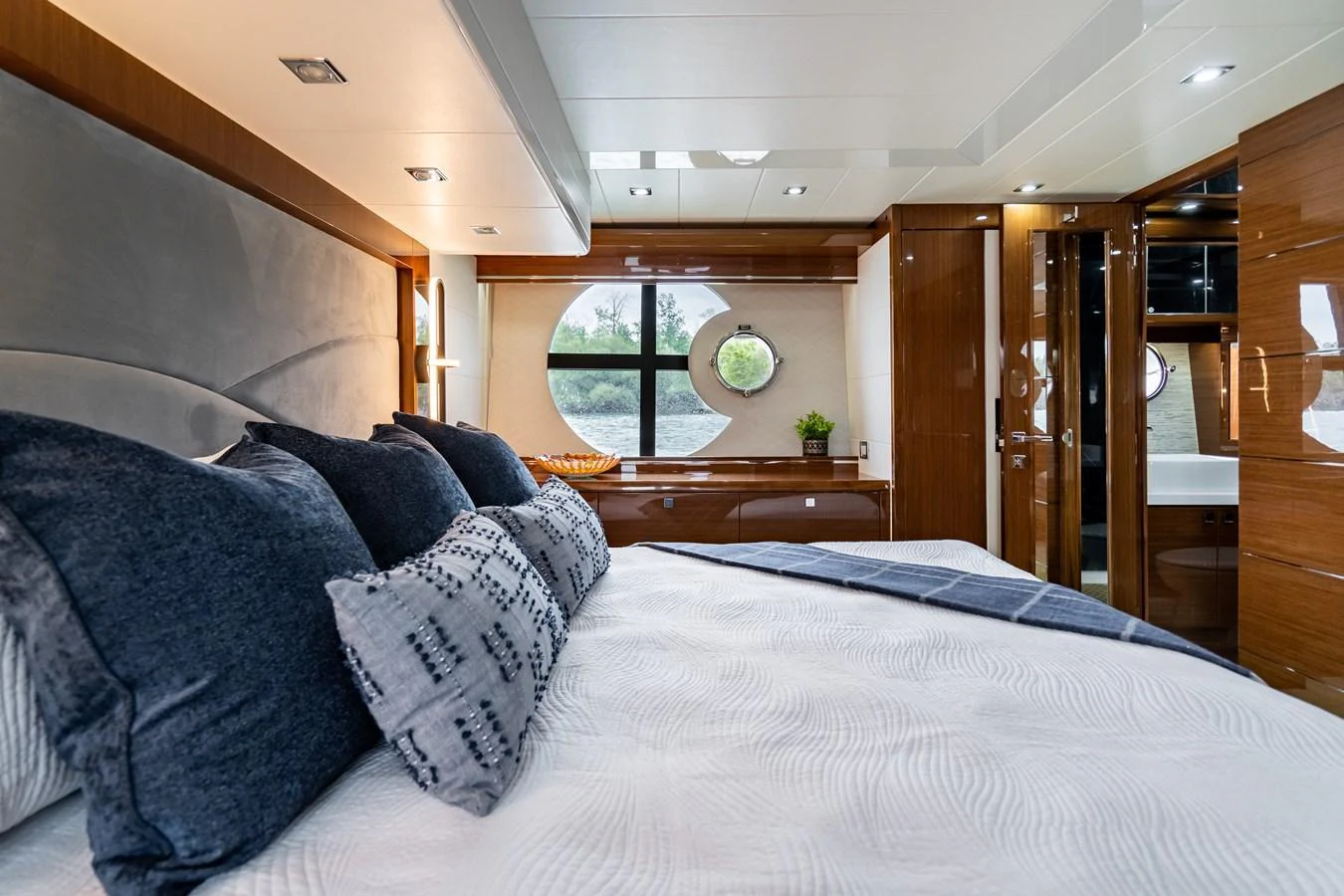 A luxurious stateroom with a large bed, elegant wood finishes, and ample natural light. aboard NEPTUNUS 650E Yacht for Sale