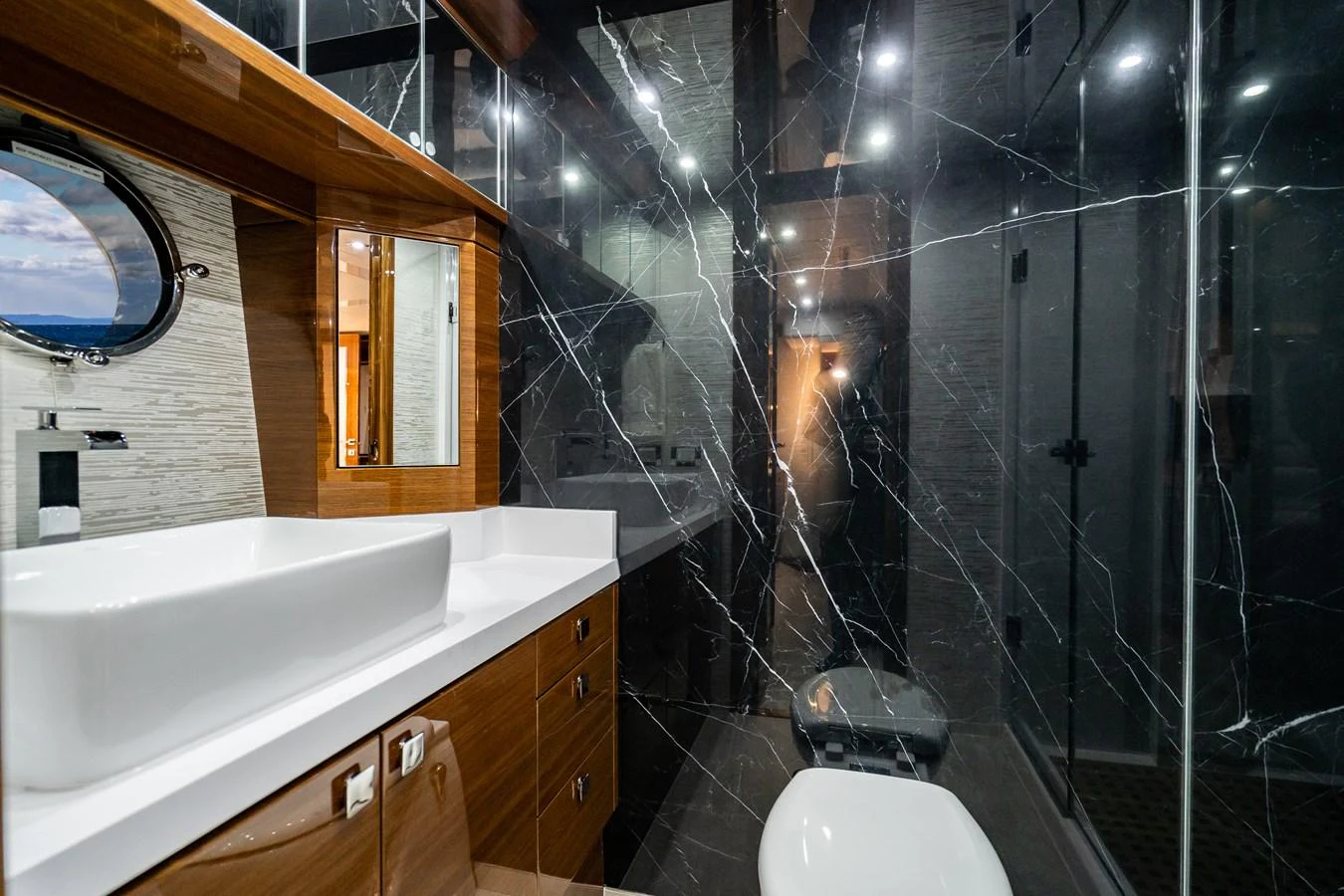 A luxurious yacht bathroom featuring sleek black marble walls and modern fixtures. aboard NEPTUNUS 650E Yacht for Sale