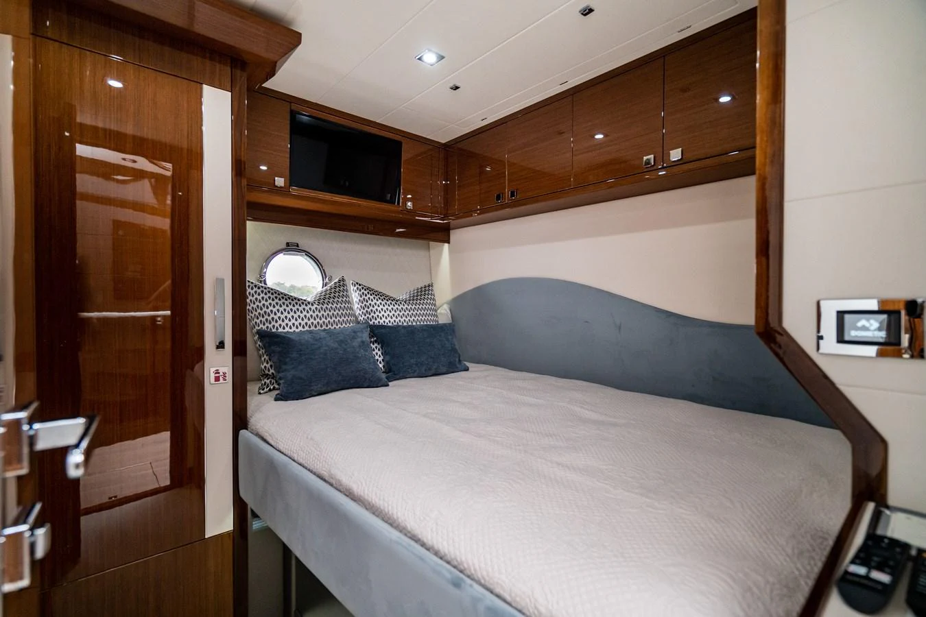 The stateroom features a cozy bed with plush pillows and elegant wood finishes. aboard NEPTUNUS 650E Yacht for Sale