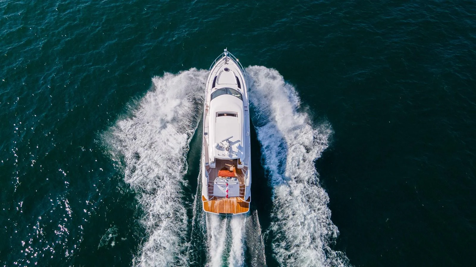 A sleek yacht cruises through the open water, leaving a trail of white waves behind. aboard NEPTUNUS 650E Yacht for Sale