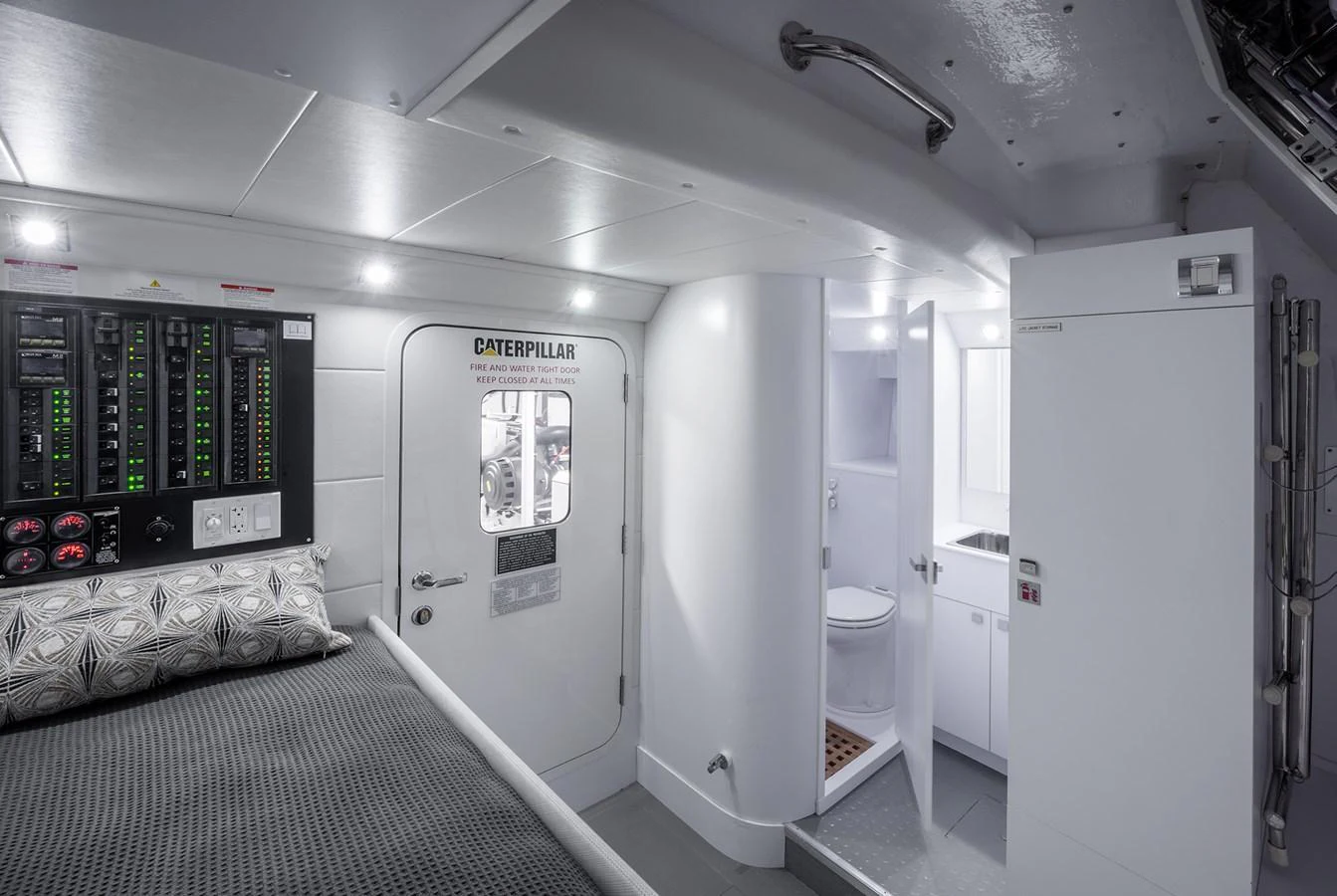 A functional and well-lit engine room with a bed and bathroom facilities. aboard NEPTUNUS 650E Yacht for Sale