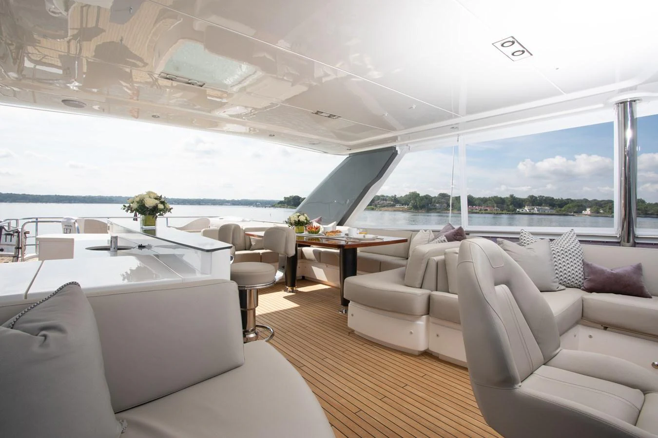a room with white couches and a large window overlooking the ocean aboard JUST PERFECT Yacht for Sale
