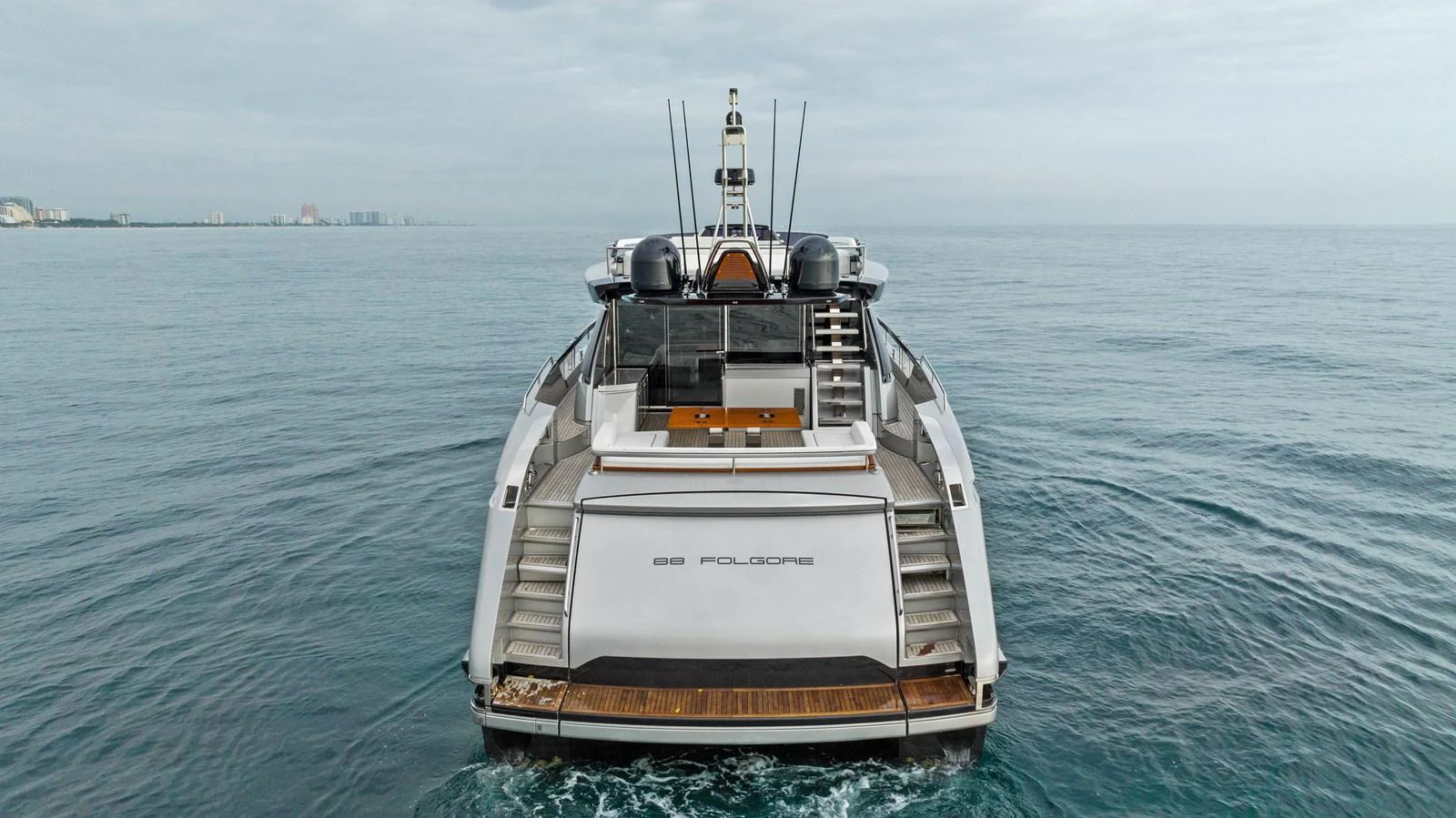 A sleek yacht is seen from the rear, showcasing its modern design and spacious deck area. aboard FERRETTI  TRADE Yacht for Sale