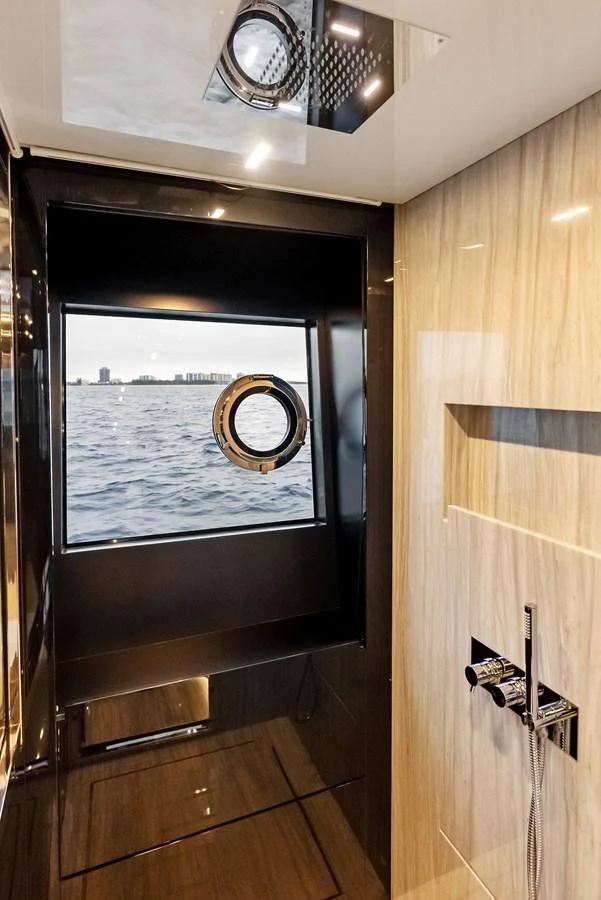 A luxurious bathroom with a porthole window offering a stunning view of the water. aboard FERRETTI  TRADE Yacht for Sale