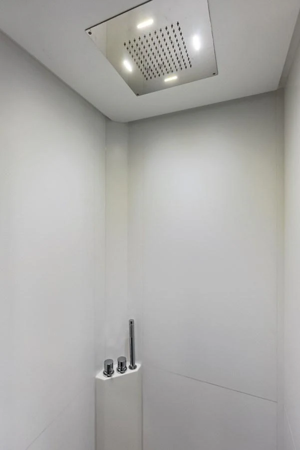 A sleek and modern yacht shower with minimalist fixtures and a ceiling-mounted showerhead. aboard FERRETTI  TRADE Yacht for Sale