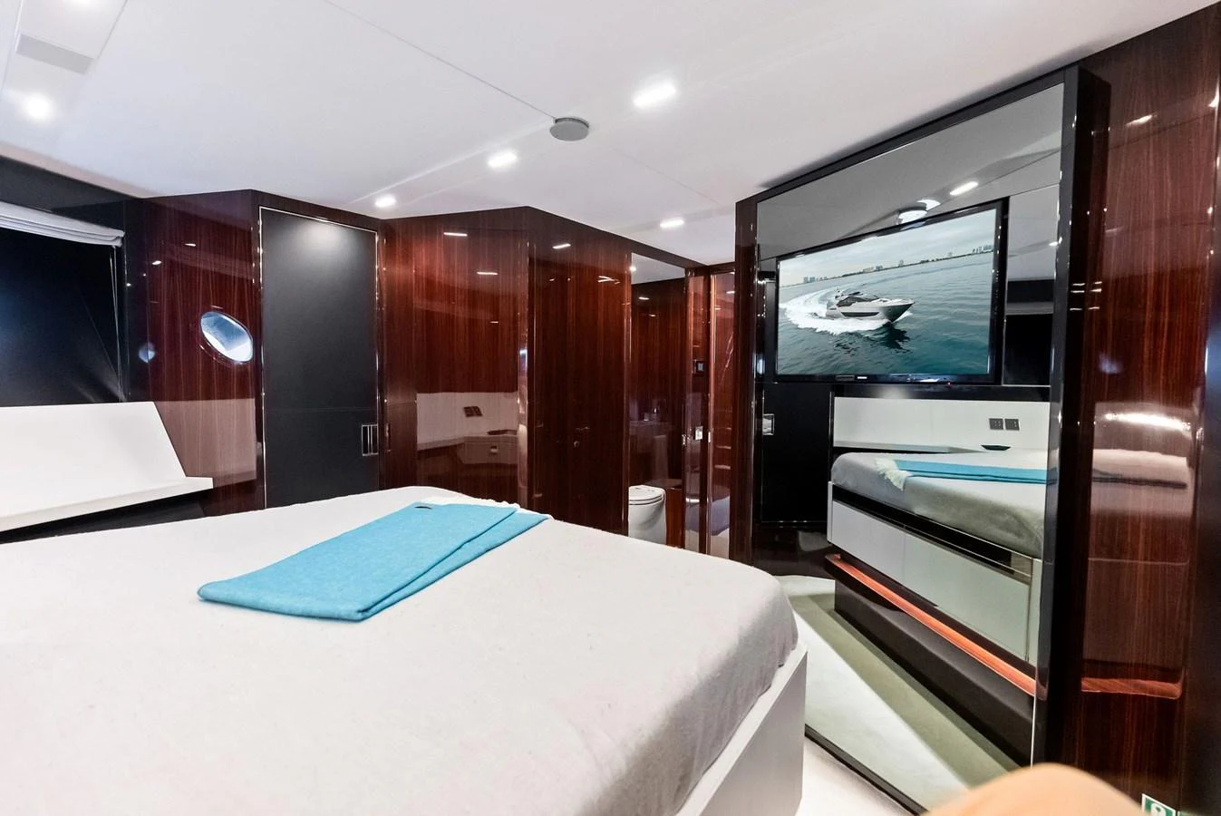 The stateroom features a luxurious bed, sleek wood finishes, and a flat-screen TV. aboard FERRETTI  TRADE Yacht for Sale