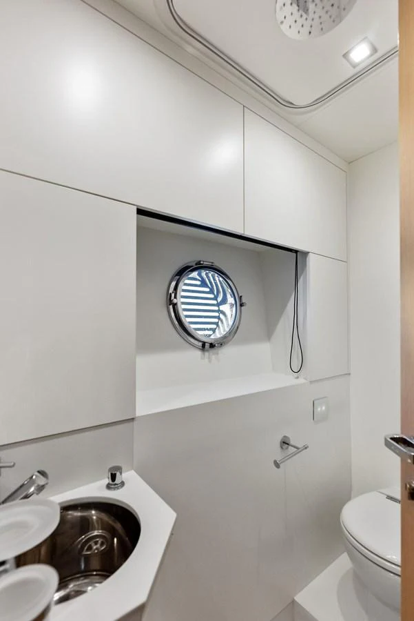 A sleek and modern yacht bathroom with a porthole window and contemporary fixtures. aboard FERRETTI  TRADE Yacht for Sale