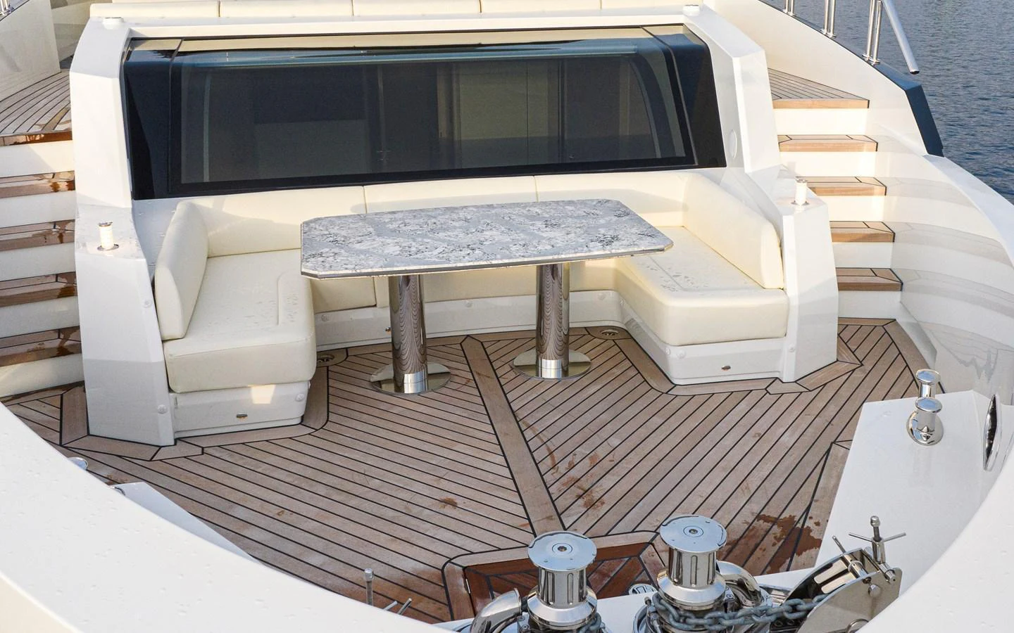 The aft deck features a stylish seating area with a marble table, perfect for outdoor dining and relaxation. aboard STILL WATERS Yacht for Sale