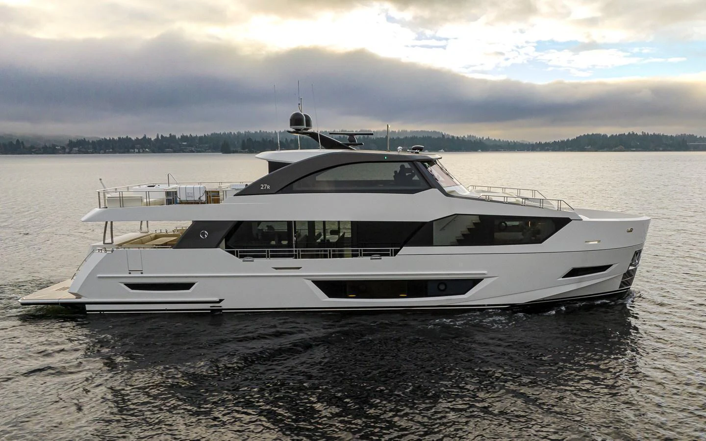 A sleek and modern yacht cruising on calm waters under a cloudy sky. aboard STILL WATERS Yacht for Sale