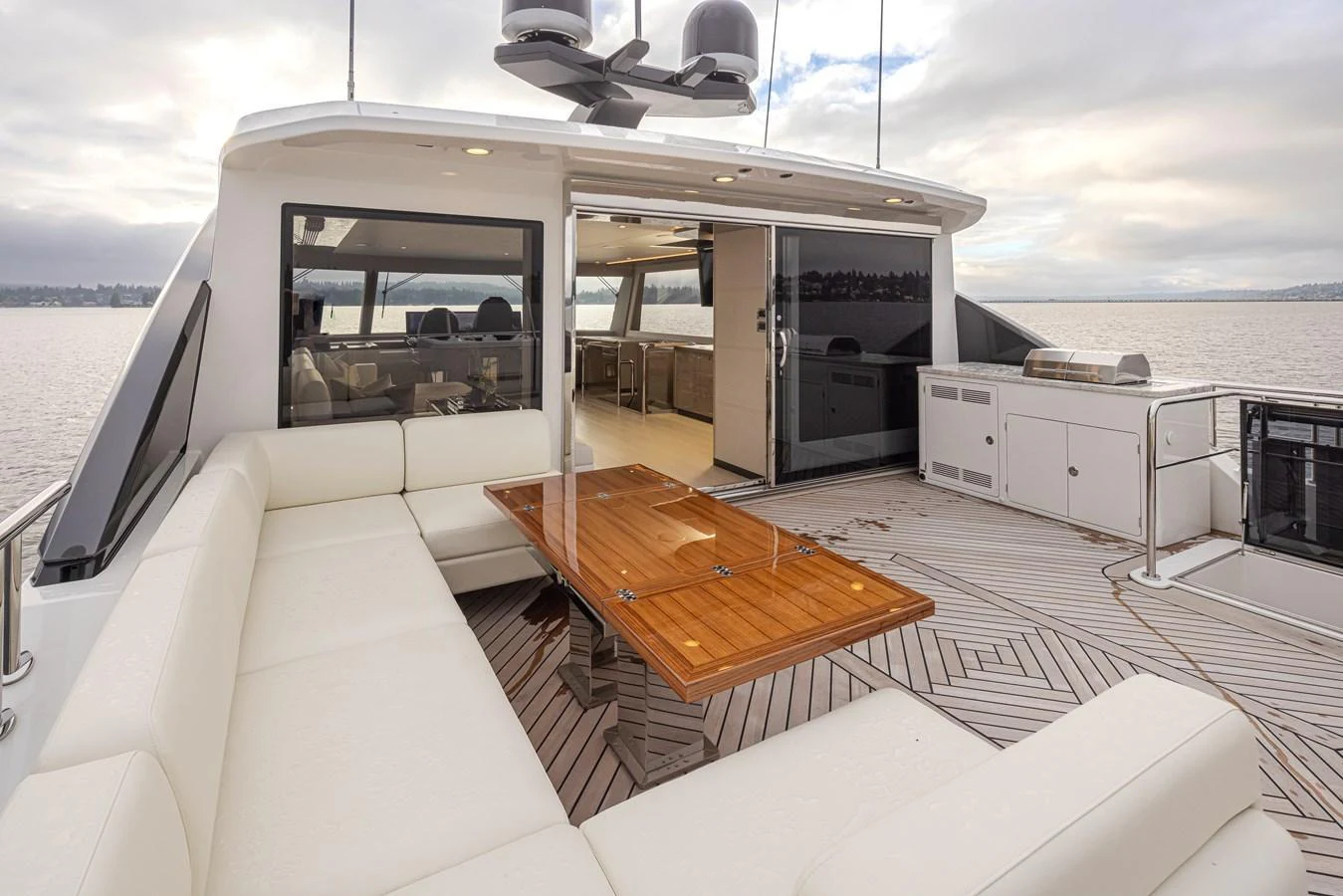 The aft deck features a spacious seating area with a wooden table, perfect for outdoor dining and relaxation. aboard STILL WATERS Yacht for Sale