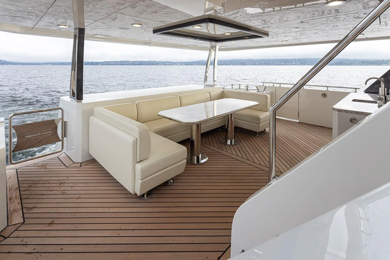 The aft deck features a comfortable seating area with a dining table, perfect for enjoying meals with a view of the water. aboard STILL WATERS Yacht for Sale