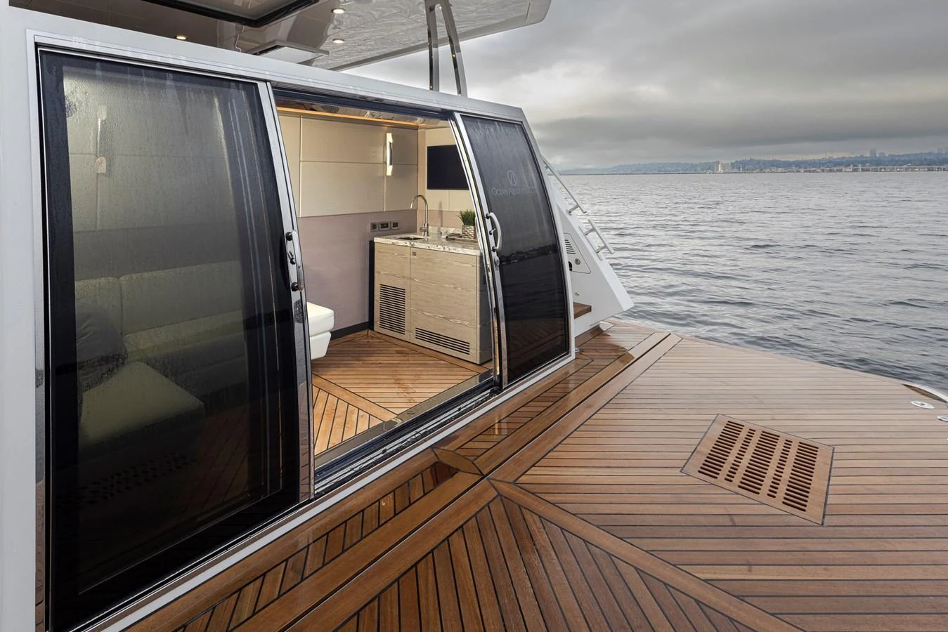 The aft deck features elegant teak flooring and a sliding glass door leading to the interior. aboard STILL WATERS Yacht for Sale
