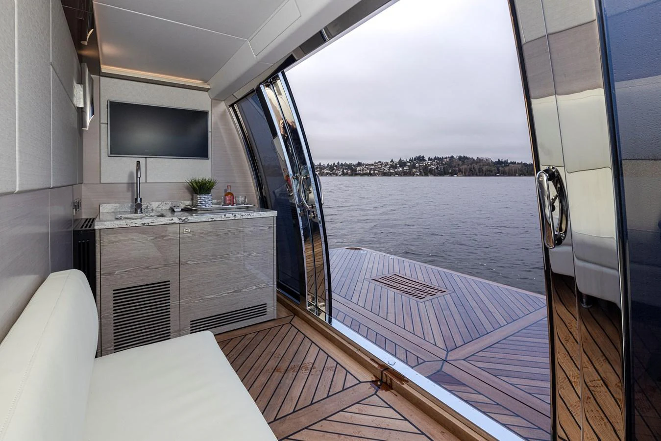 A sleek interior space opens onto a spacious deck with a view of the water. aboard STILL WATERS Yacht for Sale