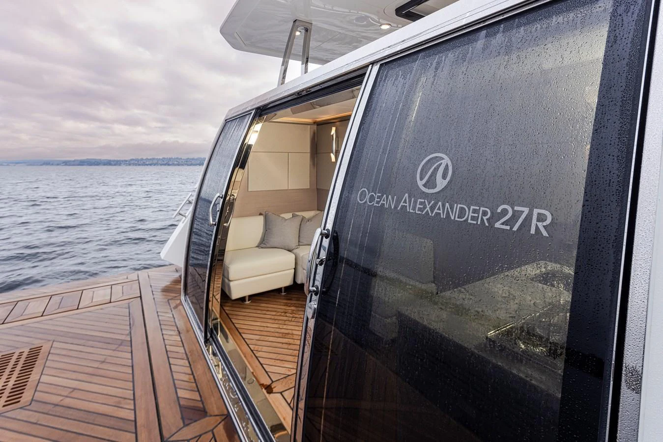 A close-up view of the yacht's sliding glass door with branding visible, leading to a cozy interior seating area. aboard STILL WATERS Yacht for Sale