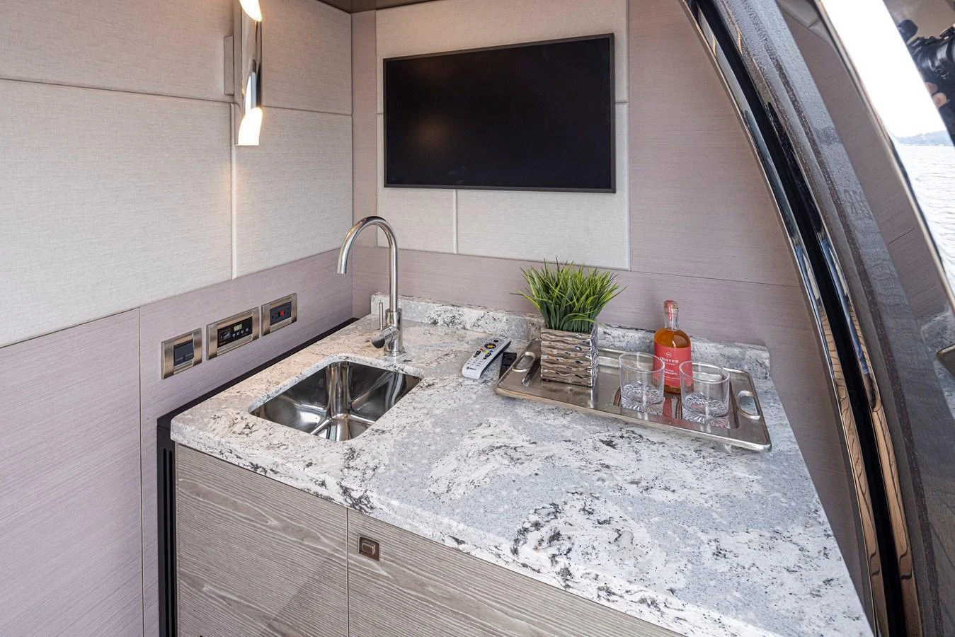 A modern galley with a sleek countertop, sink, and built-in television. aboard STILL WATERS Yacht for Sale