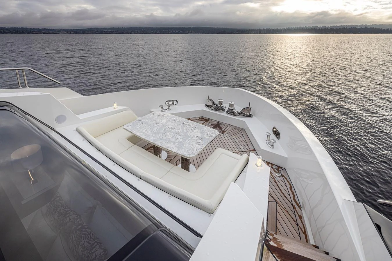 The foredeck features a luxurious seating area with a table, perfect for enjoying the serene views on the water. aboard STILL WATERS Yacht for Sale