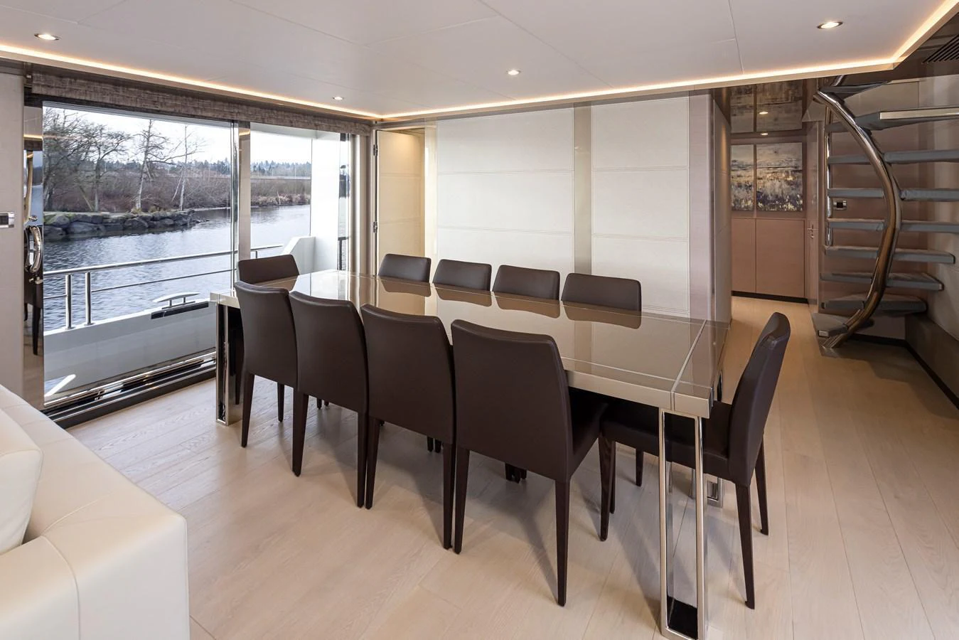 The yacht's dining area features a sleek, modern design with a large glass table and comfortable seating for eight. aboard STILL WATERS Yacht for Sale
