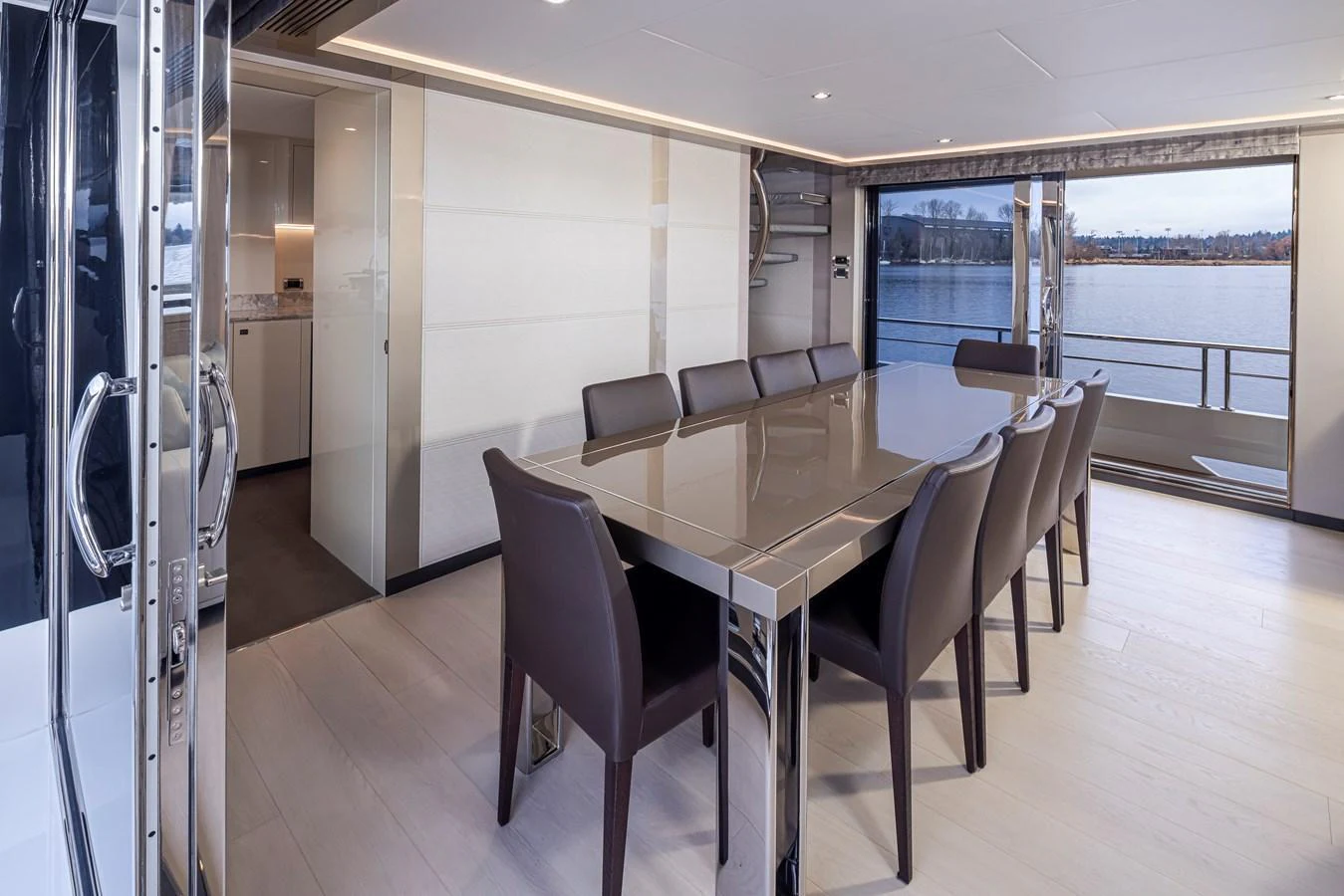 The yacht's dining area features a sleek table with comfortable seating and large windows offering stunning water views. aboard STILL WATERS Yacht for Sale