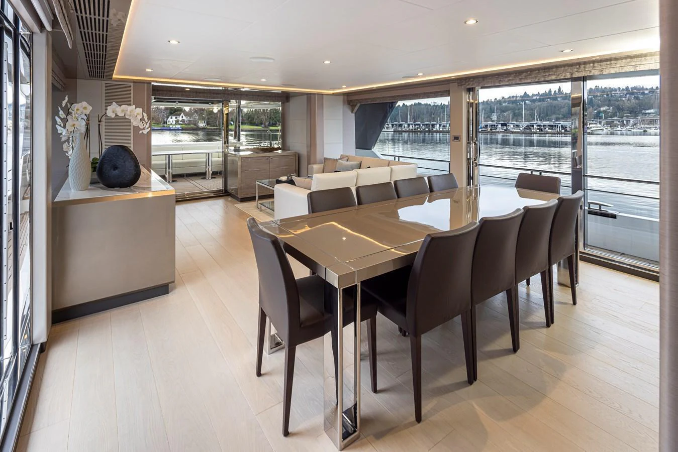A luxurious dining area with a modern table and comfortable seating, featuring large windows offering a scenic view. aboard STILL WATERS Yacht for Sale