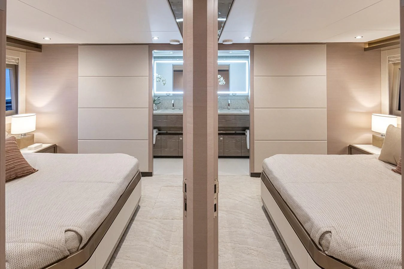 The image showcases a luxurious stateroom with two comfortable beds and modern decor. aboard STILL WATERS Yacht for Sale
