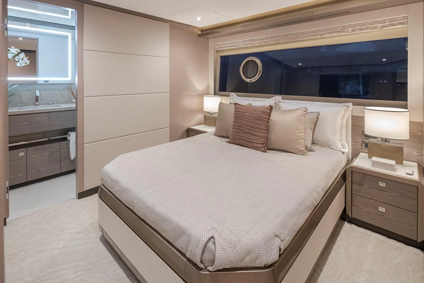 The stateroom features a plush bed with elegant bedding and ample natural light from a large window. aboard STILL WATERS Yacht for Sale