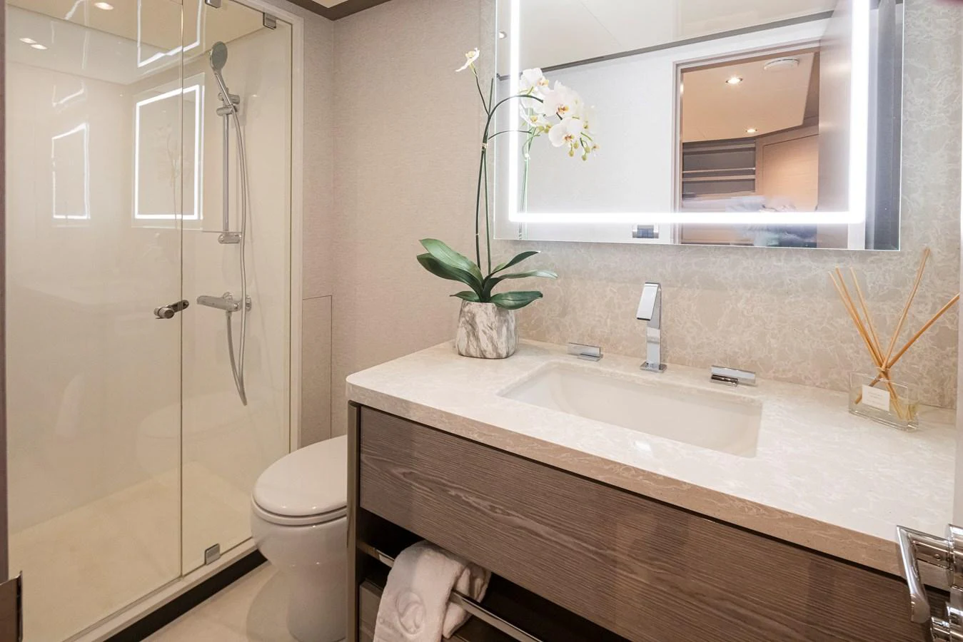 A modern and elegant yacht bathroom featuring a glass-enclosed shower, a sleek vanity, and tasteful decor. aboard STILL WATERS Yacht for Sale