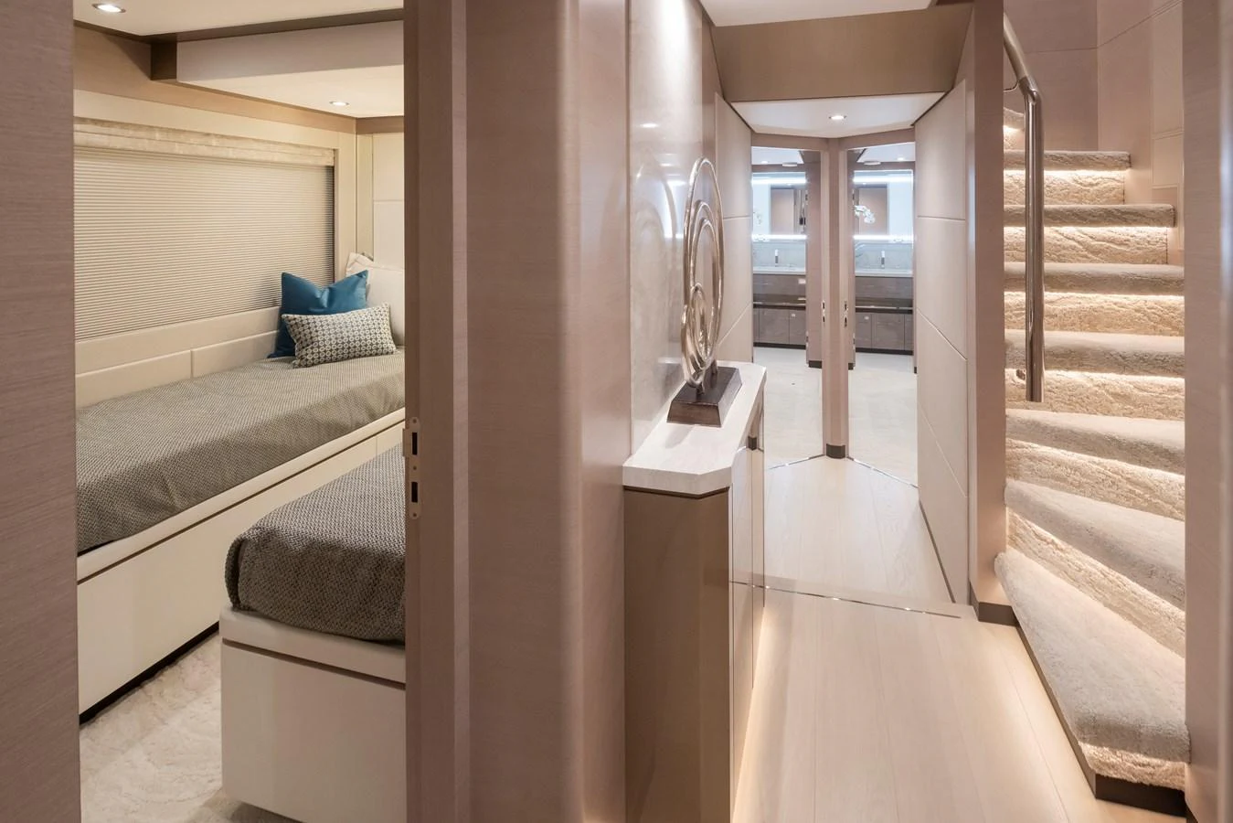 A luxurious hallway with a view into a cozy stateroom and a staircase leading to the upper deck. aboard STILL WATERS Yacht for Sale