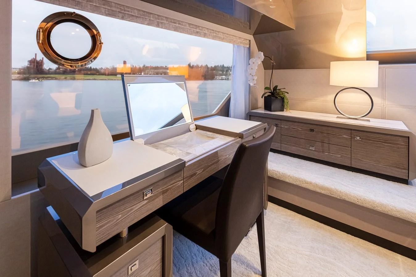 The stateroom features a sleek vanity area with a view of the water through large windows. aboard STILL WATERS Yacht for Sale