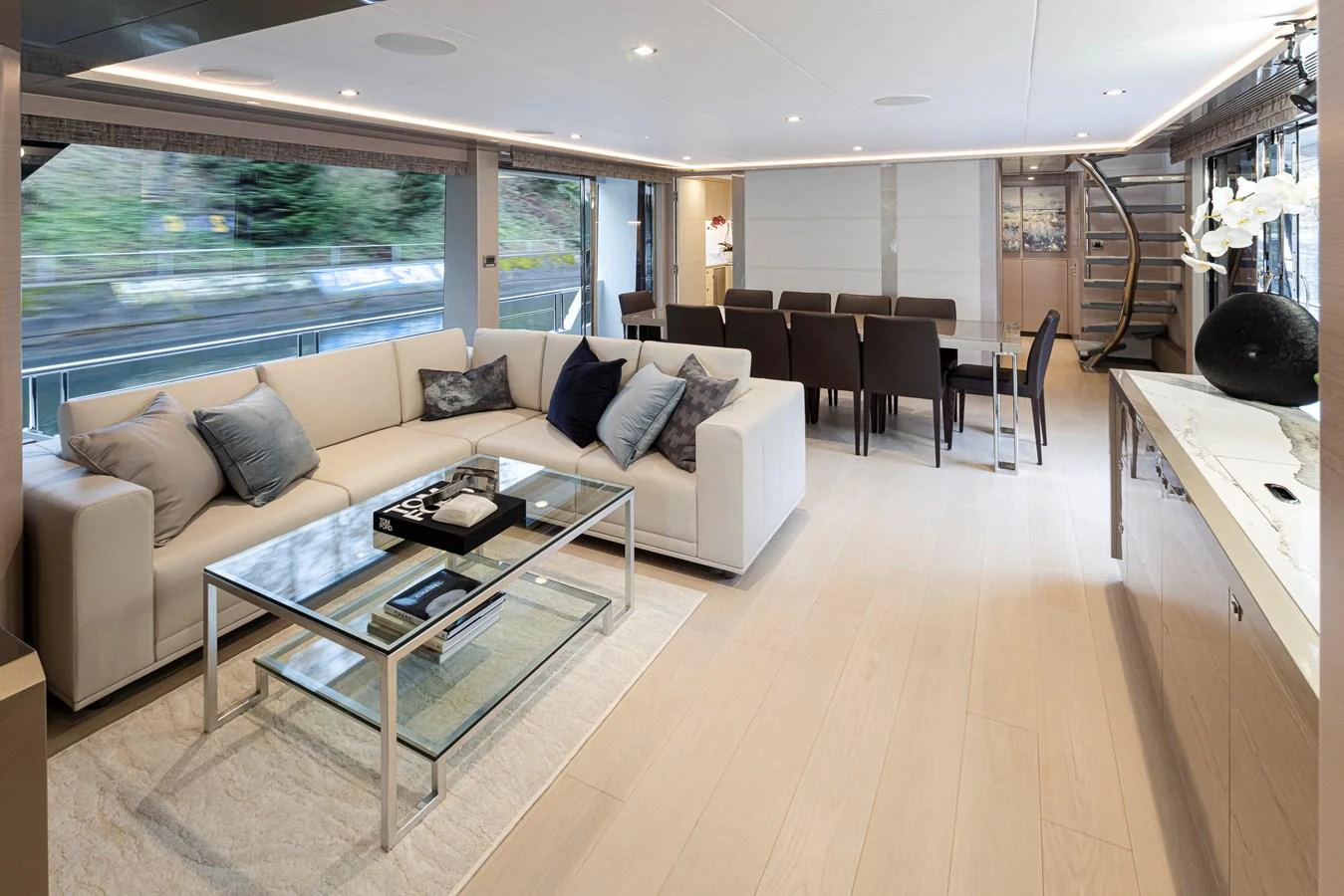 The salon features a spacious and elegantly designed seating area with a modern dining space. aboard STILL WATERS Yacht for Sale