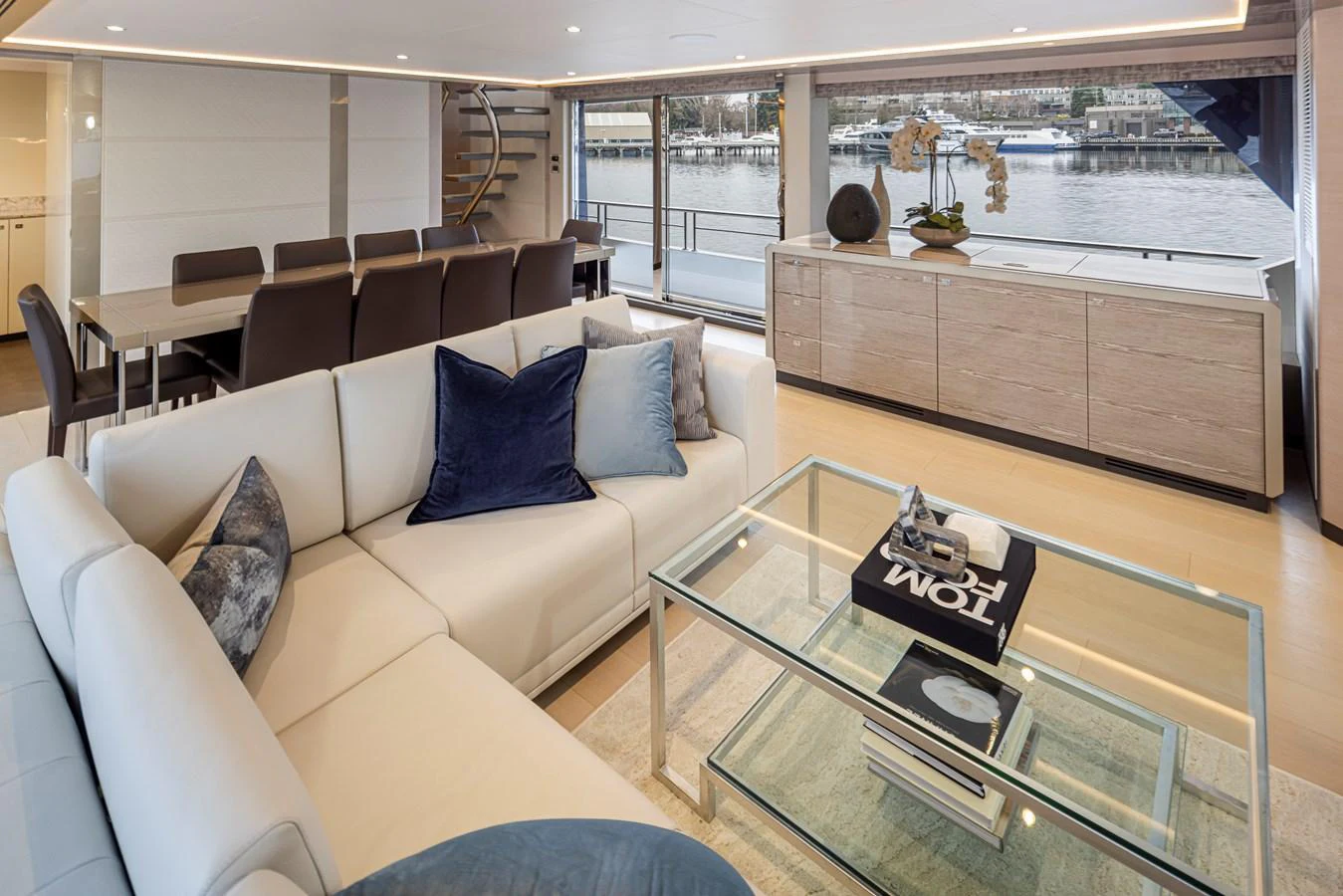 The salon features a spacious seating area with a modern design and large windows offering a view of the water. aboard STILL WATERS Yacht for Sale