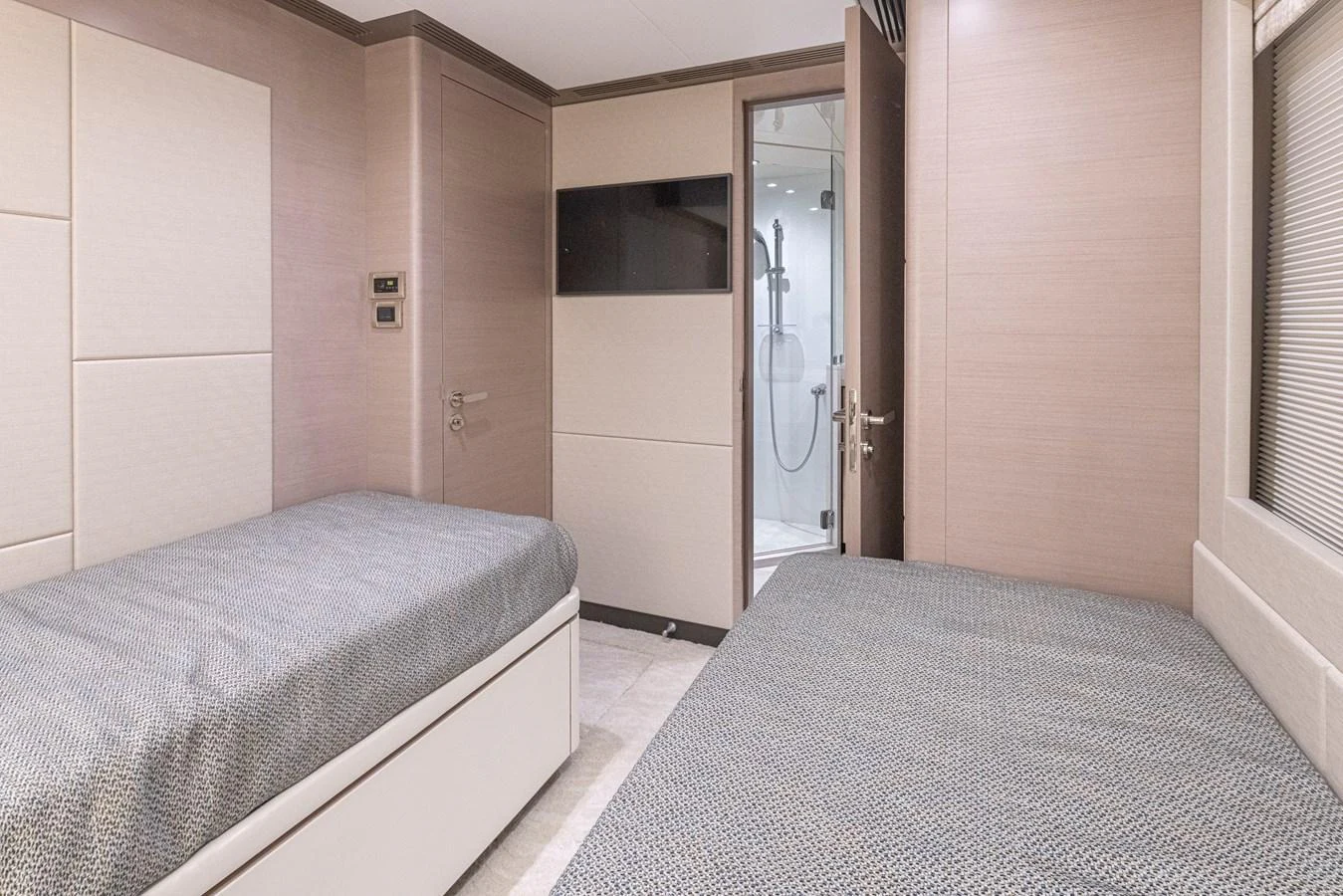 The twin stateroom features two single beds with a modern, minimalist design and an ensuite bathroom. aboard STILL WATERS Yacht for Sale