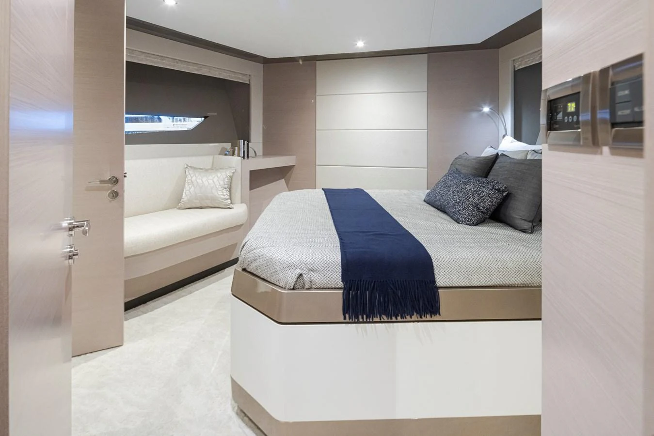 A luxurious stateroom featuring a comfortable bed with elegant bedding and a cozy seating area by the window. aboard STILL WATERS Yacht for Sale