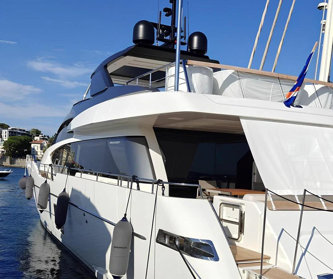 A sleek and modern yacht with a pristine white exterior is docked in a serene marina. aboard NADINKA Yacht for Sale