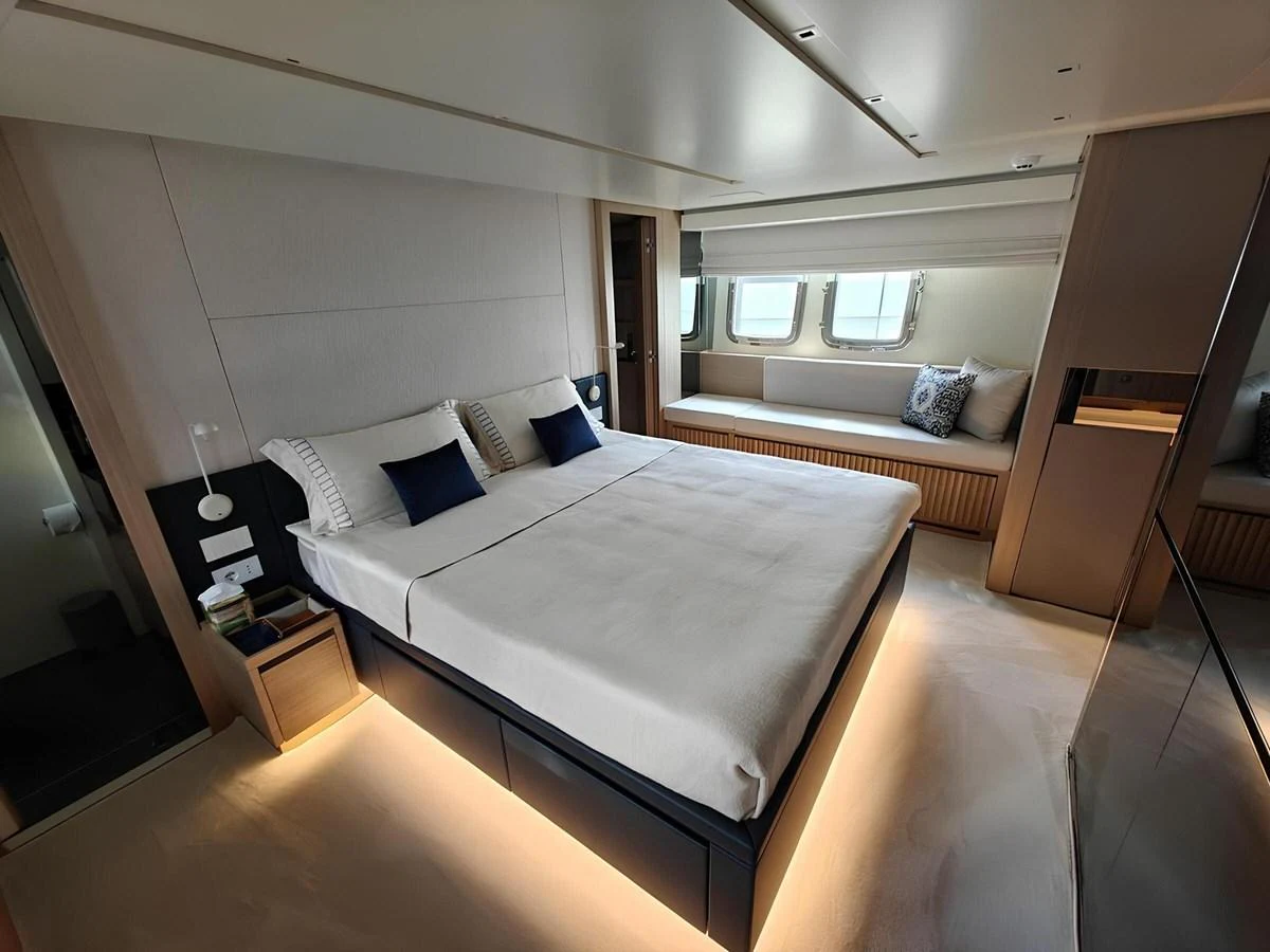 The stateroom features a luxurious bed with ambient lighting and large windows for natural light. aboard NADINKA Yacht for Sale