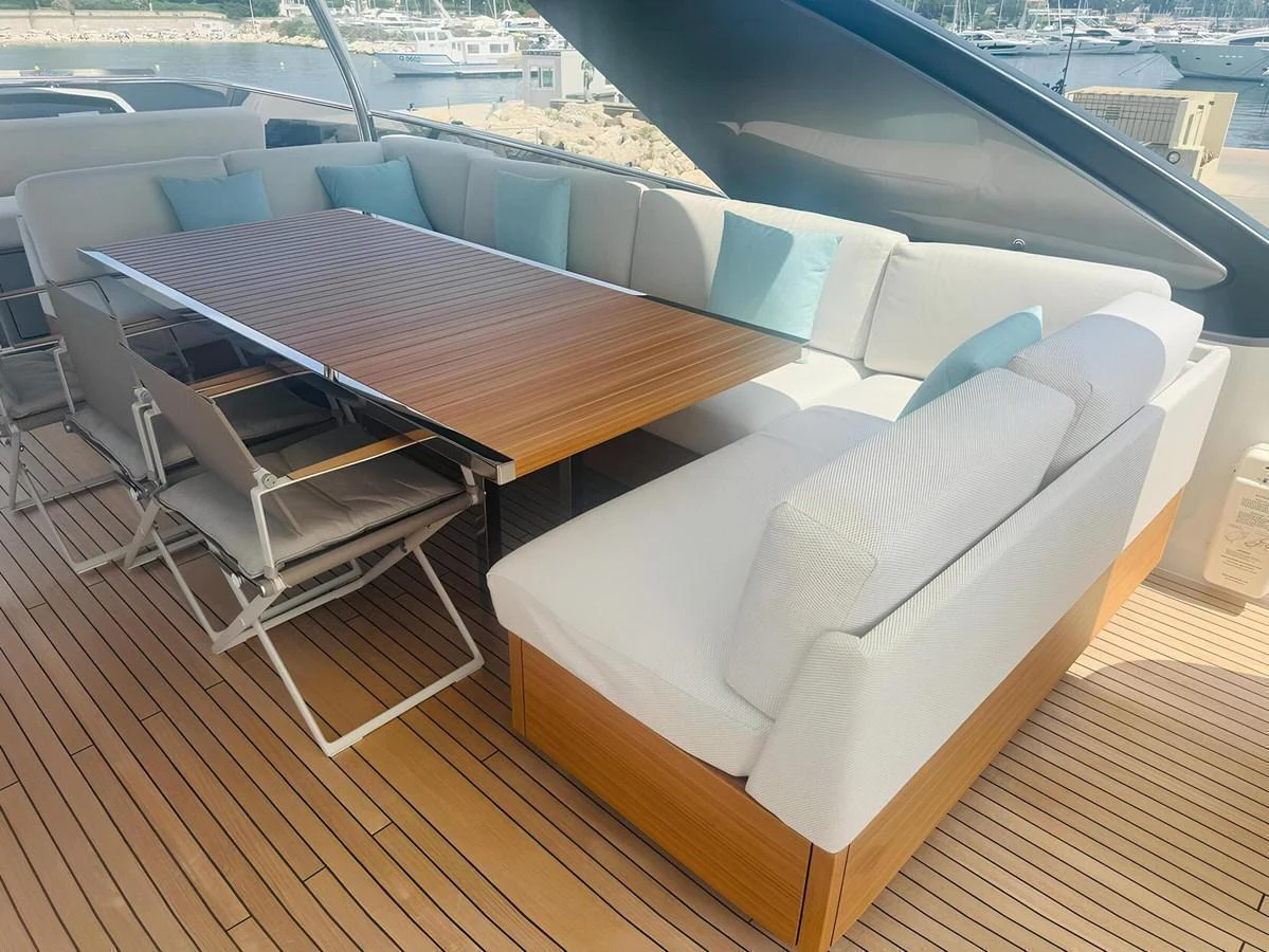 The aft deck features a spacious and comfortable seating area with a large wooden table, perfect for alfresco dining. aboard NADINKA Yacht for Sale