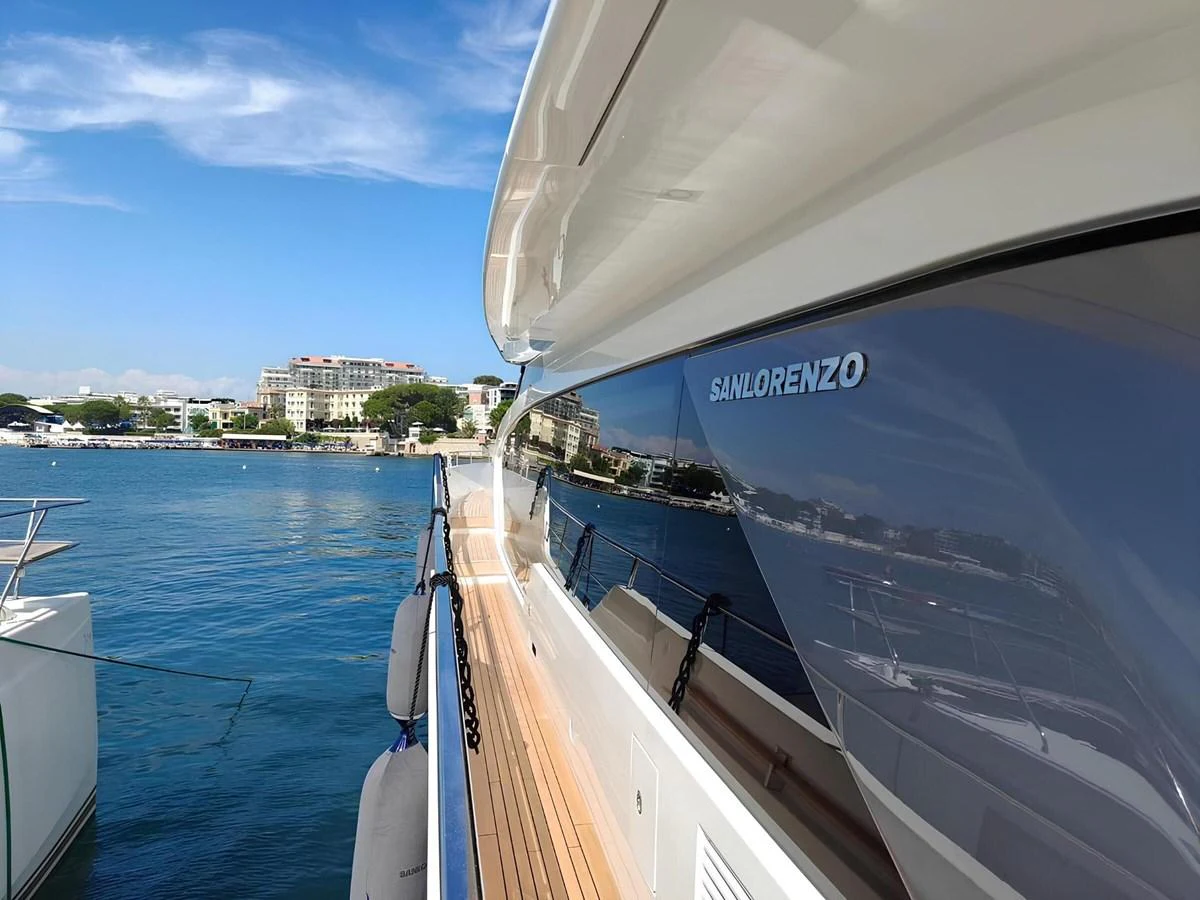 The sleek exterior of the yacht reflects the serene waters and nearby buildings. aboard NADINKA Yacht for Sale