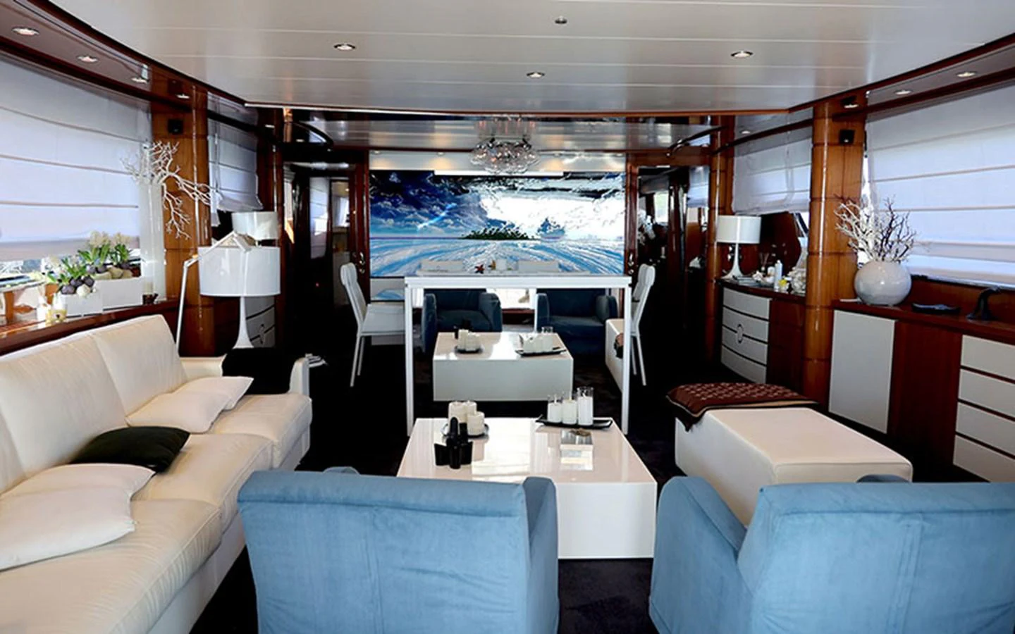 The yacht's salon features luxurious seating and elegant decor with a large screen displaying a scenic view. aboard MEP TOGETHER Yacht for Sale